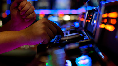 A player pushes the button on a slot machine.