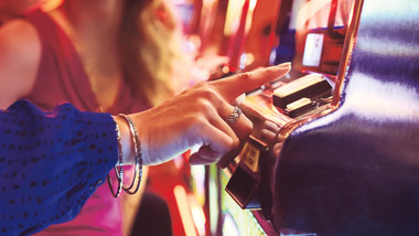 woman pushing button on slot machine
