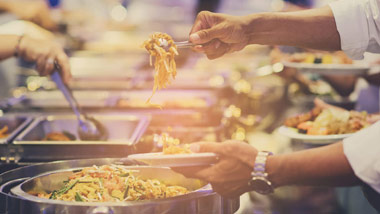 man filling plate at buffet